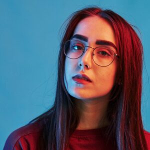 confident look studio shot indoors with neon light portrait of beautiful young girl e1674113746744